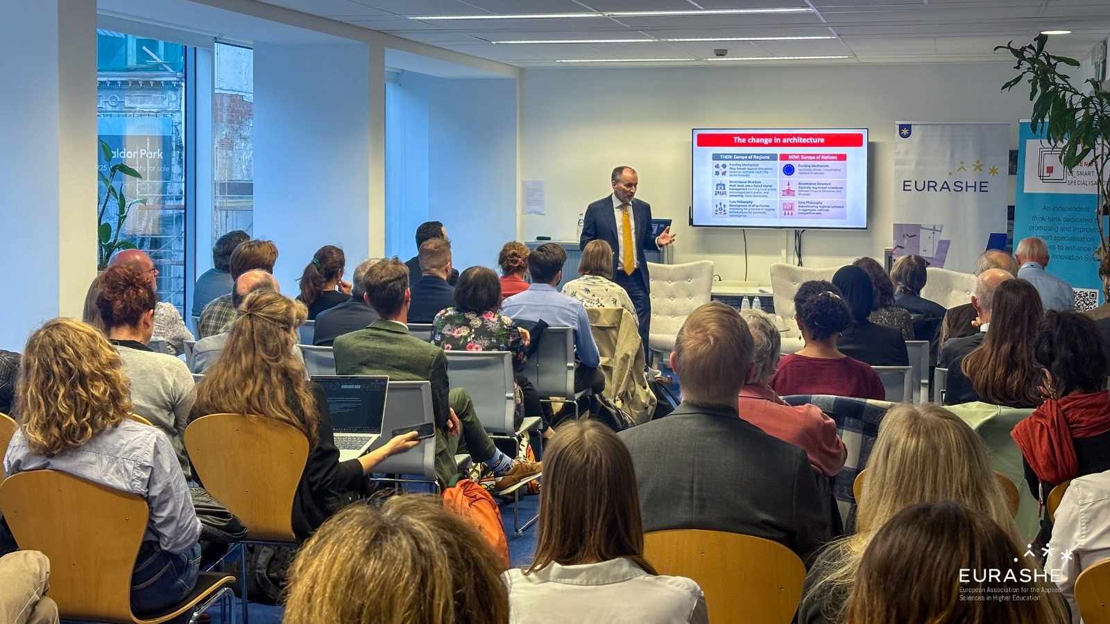 A person giving a presentation to a room full of people
